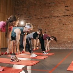 Fitness group performing exercises with dumbbells in a modern yoga studio setting.
